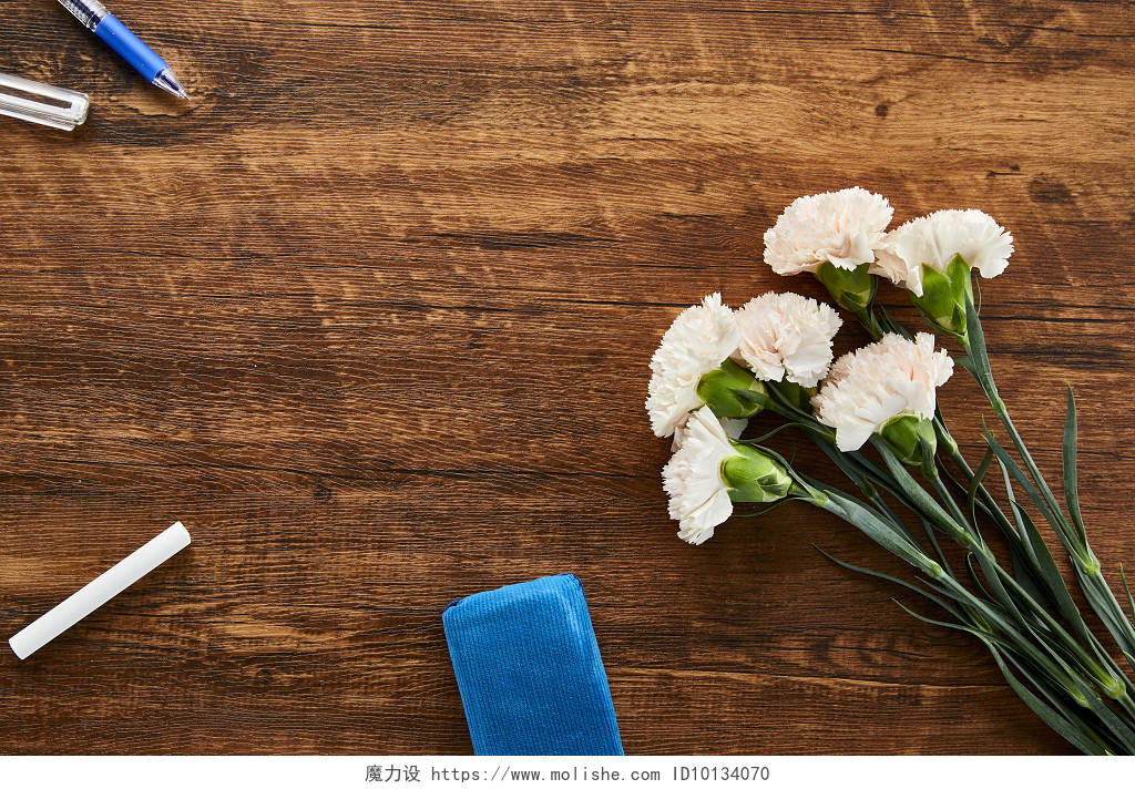 鲜花花朵多束康乃馨黑板擦粉笔圆珠笔在木桌背景上的场景素材俯视图教师节